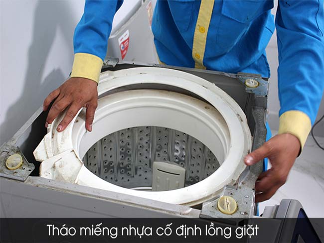 Tháo miếng nhựa cố định ở nắp máy giặt